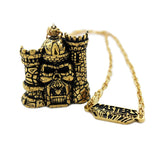 front of the castle grayskull pendant in gold from the masters of the universe collection