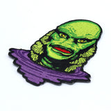 angled shot of the Creature Lurking Patch from the universal monsters jewelry collection