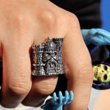 shot of the Castle grayskull ring on a mans hand holding a vintage skeletor toy