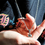 shot of a man wearing a black t shirt holding the d20 pendant while he is wearing it