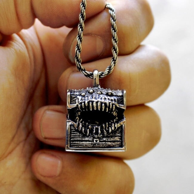 Dungeons & Dragons Mimic Monster Necklace, Hand holding necklace for close up view of mimic pendant in silver