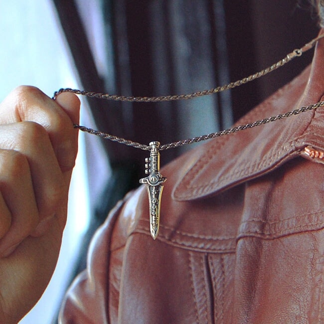 photo of a man in a brown leather jacket showing the green ranger dragon dagger pendant on a chain