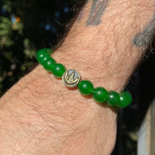 green aventurine power rangers bead bracelet worn by a man with tattoos in the sun