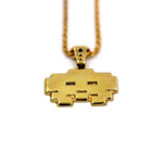 up close view of the grumpy invader pendant in gold on a white background