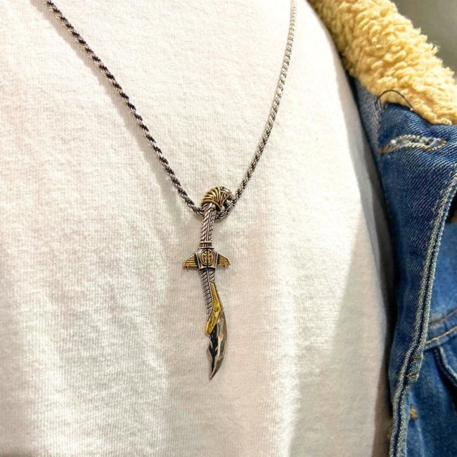front view of the mighty morphin power rangers Legacy Saba Sword Pendant on a man in a white t shirt