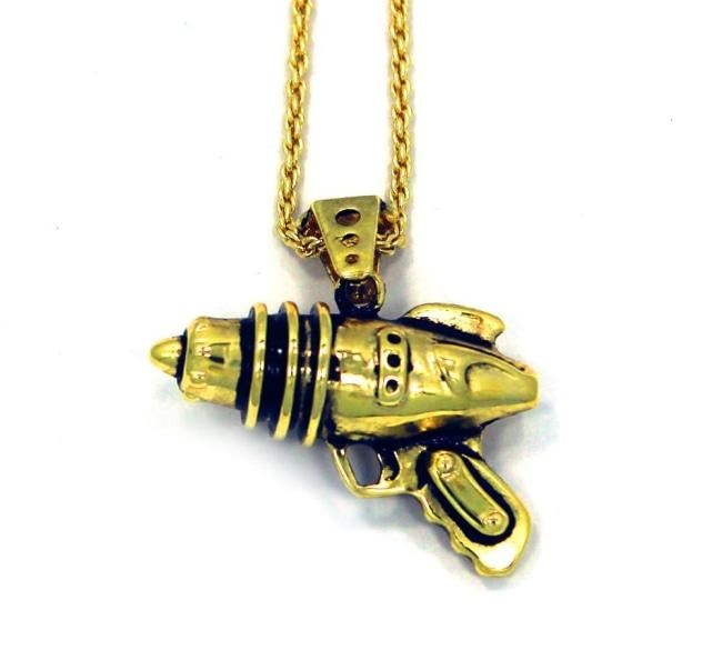 right side shot of the Ray Gun Pendant in gold on a white surface