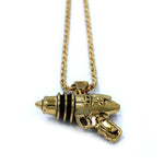 right up close shot of the Ray Gun Pendant in gold on a white surface