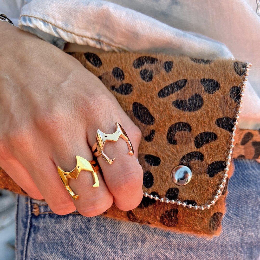 shot of a woman wearing the catra ring in gold and silver from the she-ra collection