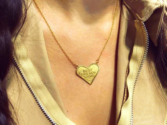 shot of the best friends squad pendant being worn on a woman with the pendant laying on her chest