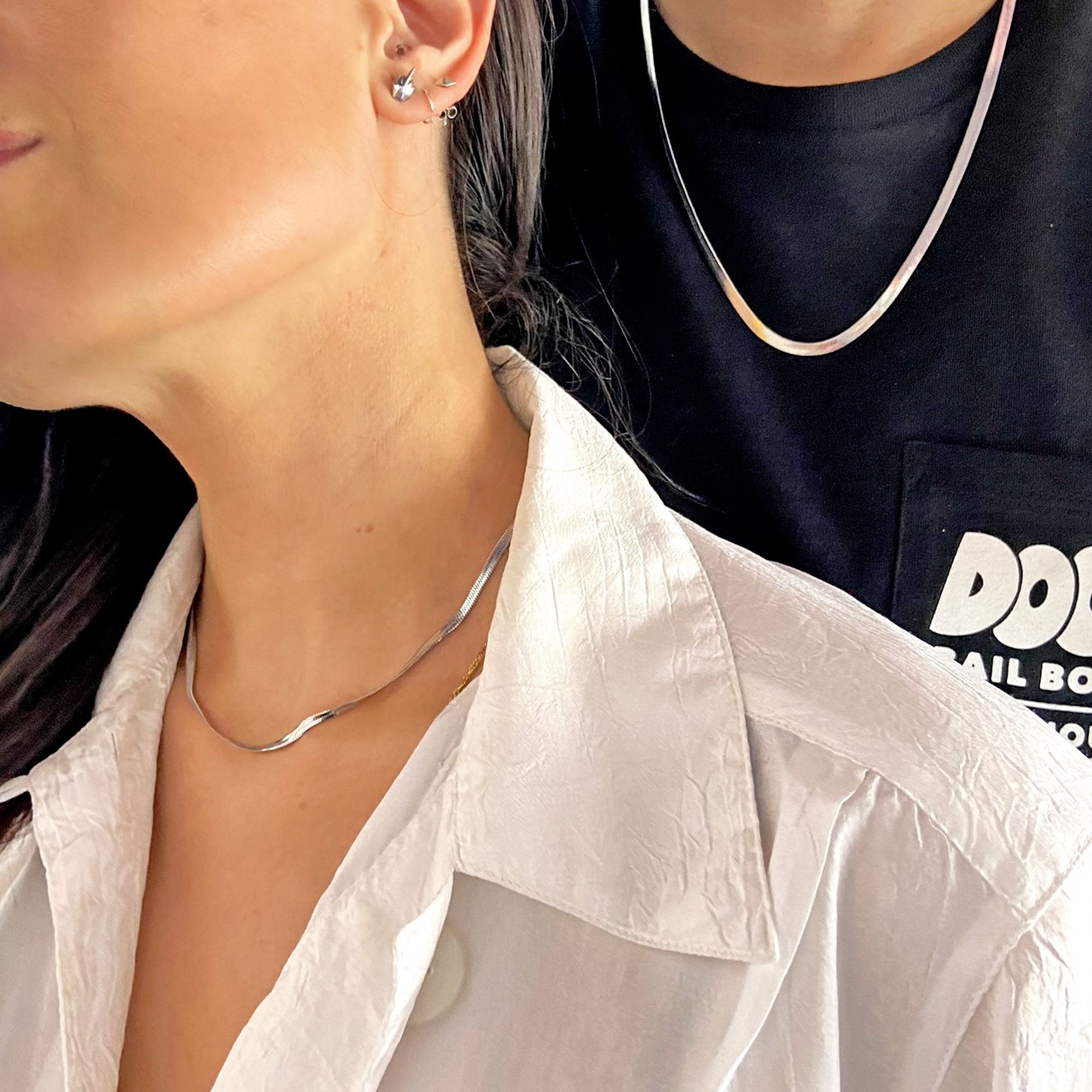 woman wearing silver herringbone chain with man wearing silver herringbone chain