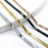 shot of the of the gunmetal, silver, gold and rose gold herring bone chains side by side on marble