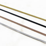 shot of the of the gunmetal, silver, gold and rose gold herring bone chains side by side on marble