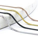 shot of the of the gunmetal, silver, gold and rose gold herring bone chains side by side on marble