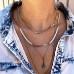 shot of a woman wearing the 3mm and 4mm herring bone chains and other chains in a denim jacket