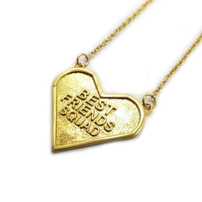 angled view of the best friends squad gold heart shaped pendant pointing to the left