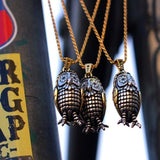 shot of 3 big bobo owl pendants hanging on a chainlink fence