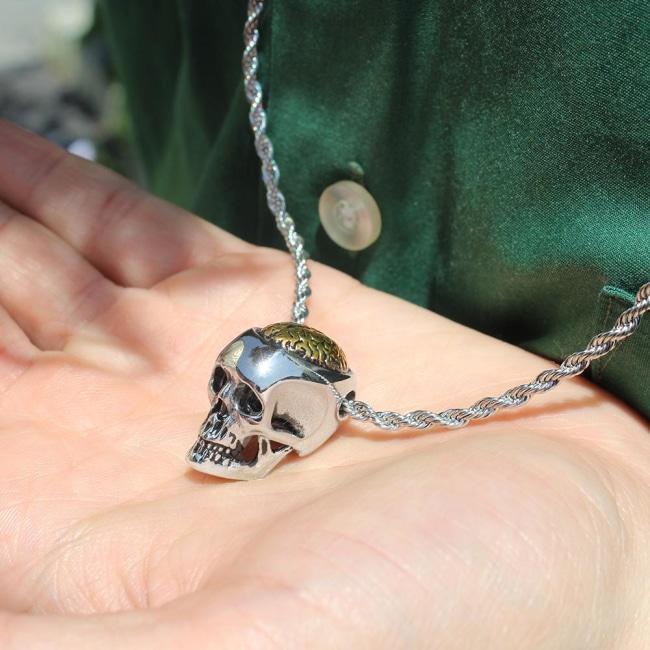 shot of a man holding the Brain Dead Pendant from the han cholo skulls collection