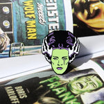 shot of the bride tears enamel pin in the pages of a universal monsters illustration book