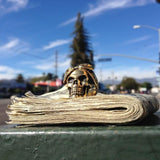 shot of the cali love ring in gold on top of a stack of money