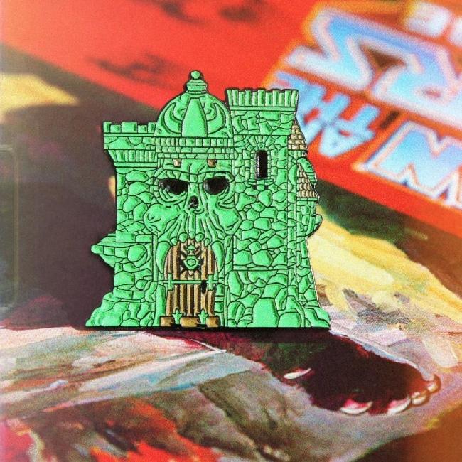 shot of the castle grayskull enamel pin on a masters of the universe book