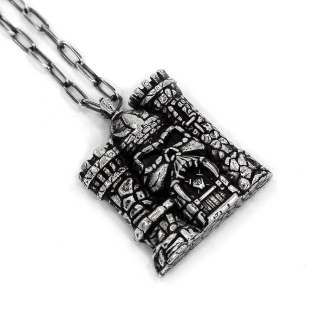 left angle of the castle grayskull pendant in silver from the masters of the universe collection