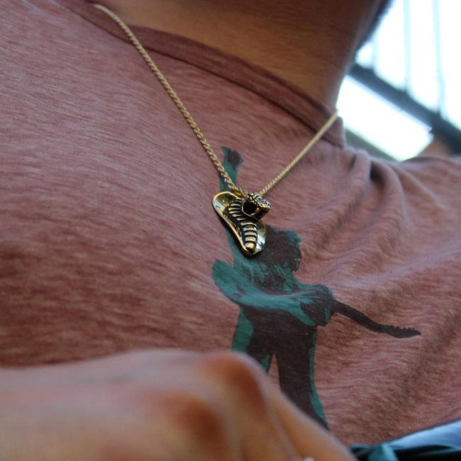 shot of a man wearing the Cobra Lover Pendant in gold from the fantasy collection