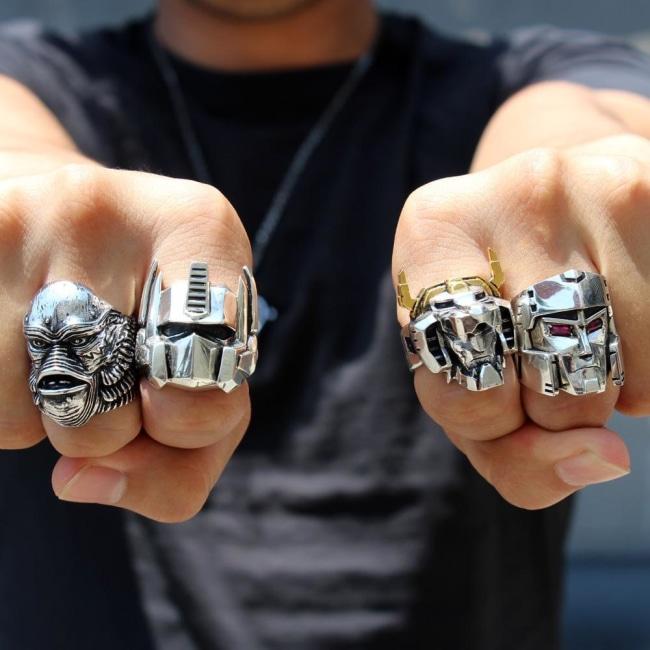 shot of a man wearing the creature, voltron, optimus prime and megatron rings on his fists