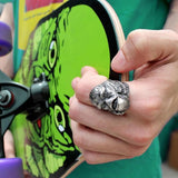 man wearing the Creature From The Black Lagoon Ring holding a creature skate deck