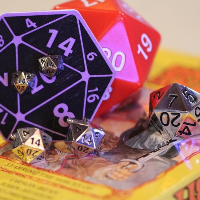 shot of the d20 stud earrings, d20 ring and d20 cufflinks on a classic fantasy vhs cover