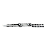 shot of the Dragon Dagger Pendant laying flat on a white surface showing side detail
