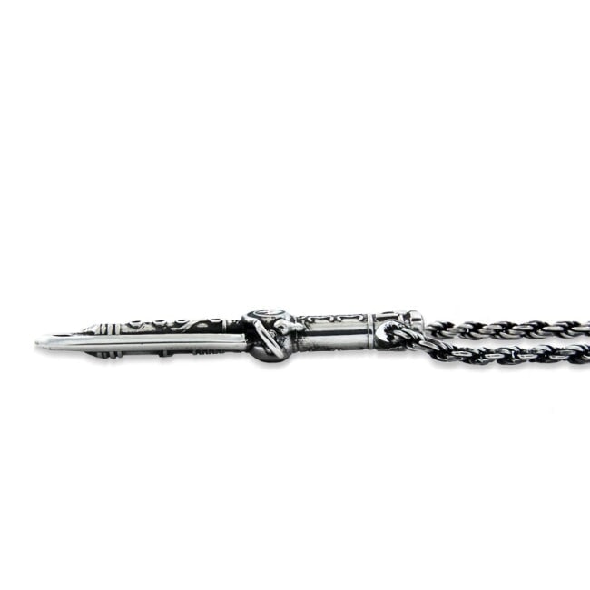 shot of the Dragon Dagger Pendant laying flat on a white surface showing side detail