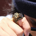 shot of a man wearing the dragon ring in gold with white stone eyes