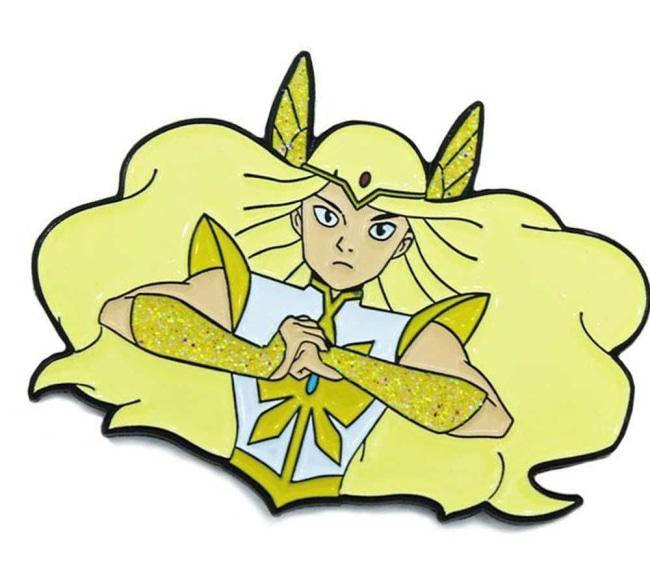 up close angled view of She-Ra enamel pin in her transformation pose with glitter armor detail