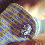 shot of the monster cufflink on a mans blue and yellow striped shirt