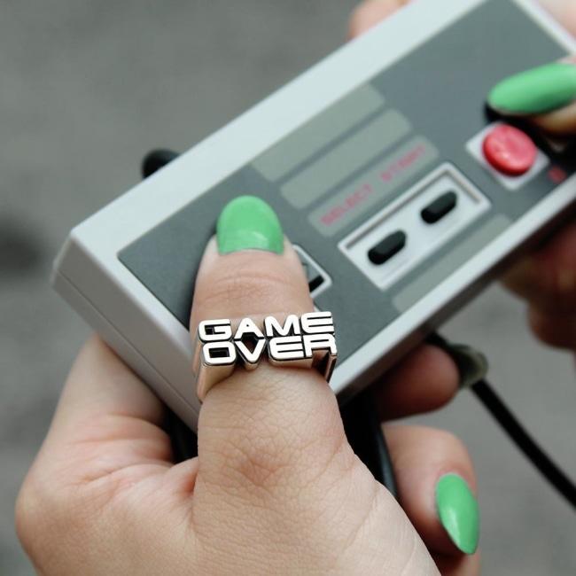 shot of a girl playing with a nintendo DS controller wearing the game over ring