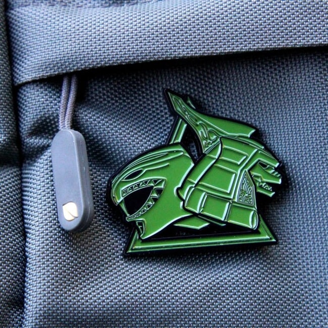 up close shot of the green ranger dragonzord enamel pin on backpack