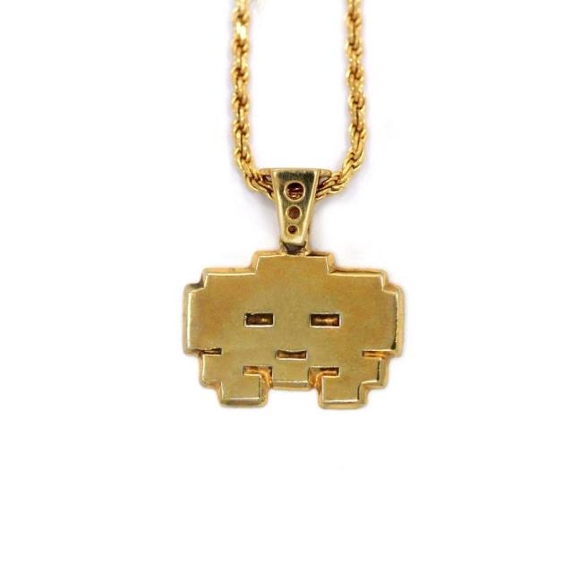 front view of the grumpy invader pendant in gold on a white background