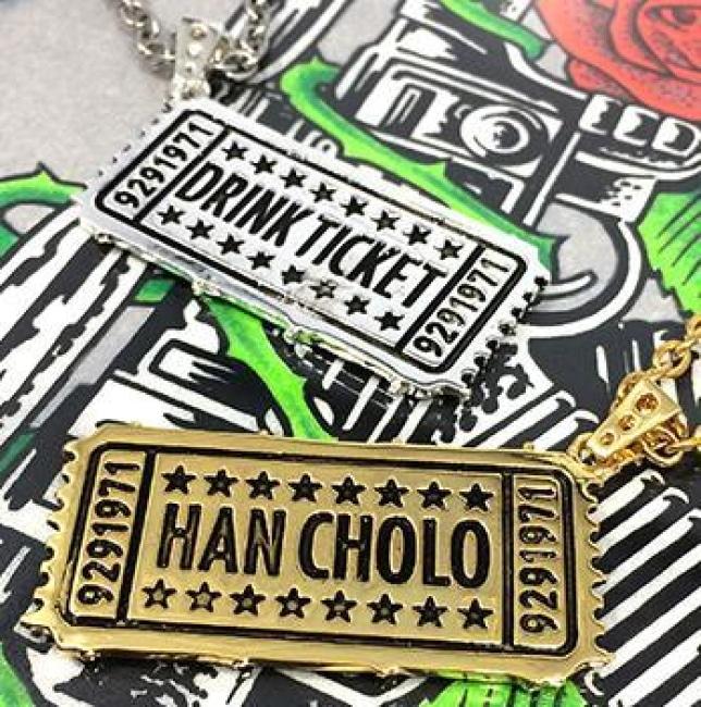 shot of the drink ticket pendant in gold and silver on the hc roses graphic t shirt