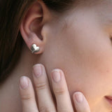 shot of a woman wearing the Heart Stud Earrings in silver from the shadow series collection