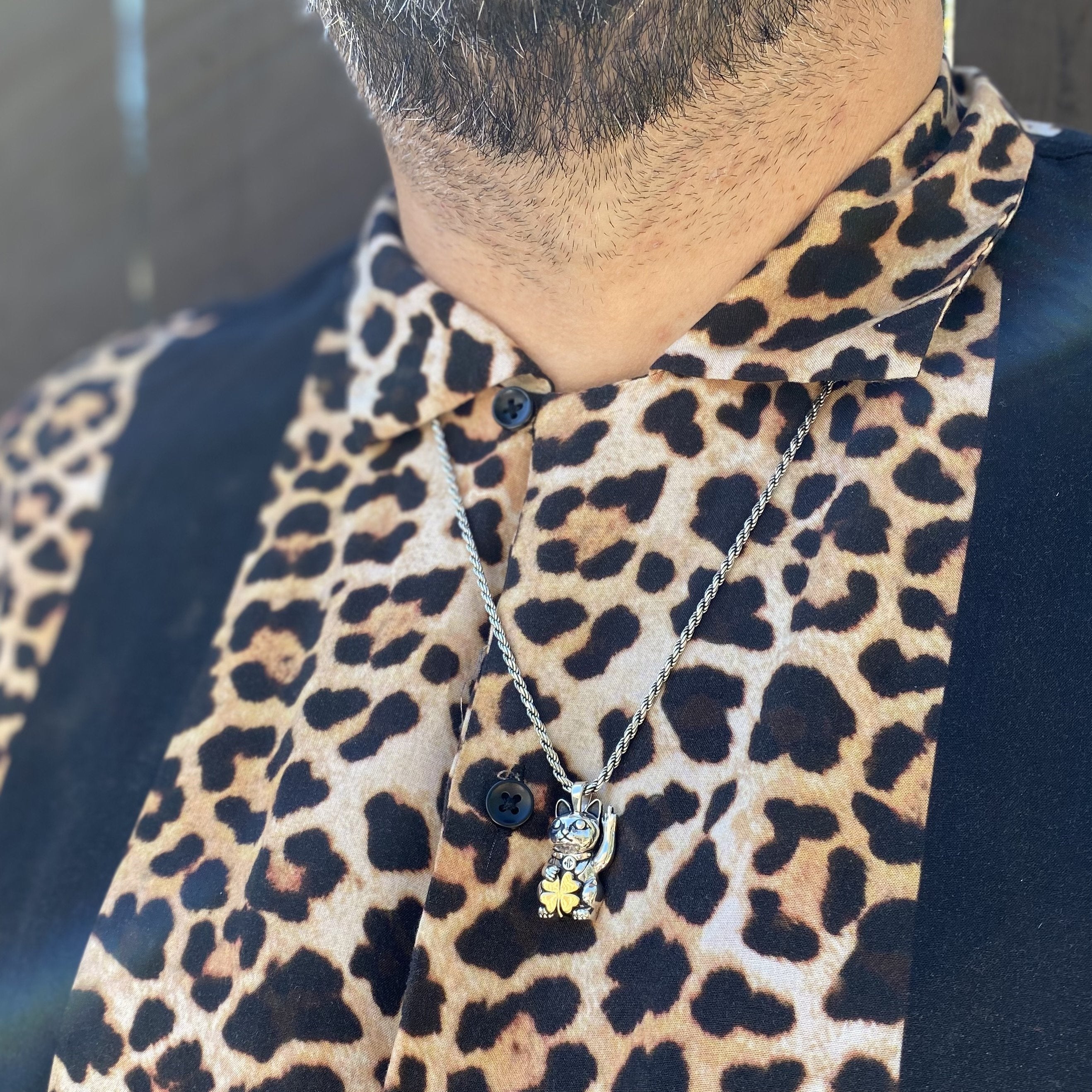 unlucky cat pendant on leopard shirt silver and gold
