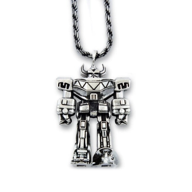 silver megazord pendant from the mighty morphin power rangers laying flat on a white background