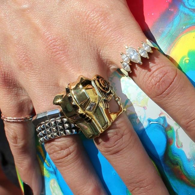 shot of a woman wearing the lioness ring with other gold rings