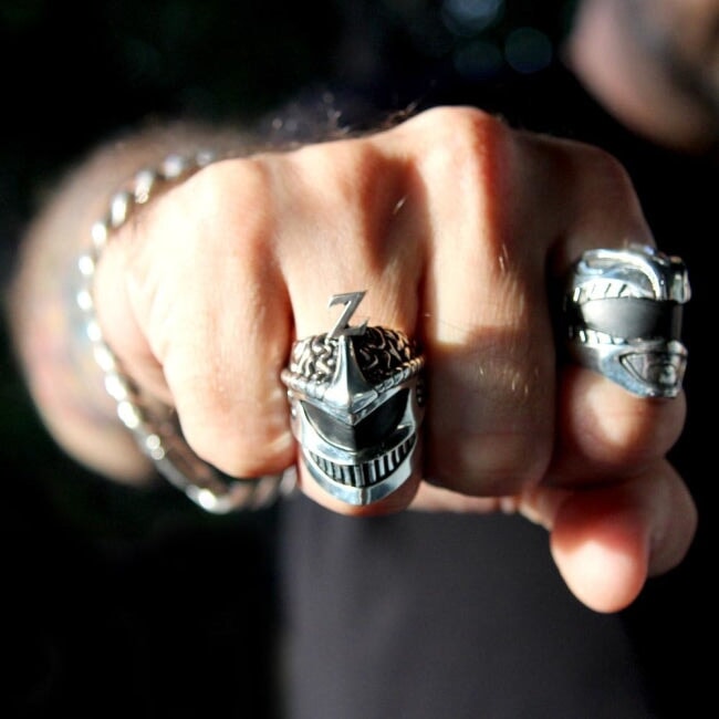 shot of the lord zedd ring and the green ranger ring on a fist in shadow and light