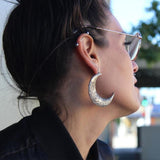 shot of a woman wearing the moon earrings in silver from the han cholo fantasy collection
