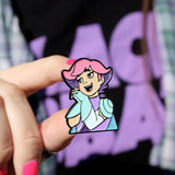 princess glimmer enamel pin being held by a woman with pink nails wearing a graphic tee
