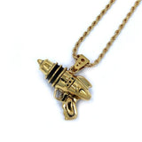 right angled shot of the Ray Gun Pendant in gold on a white surface