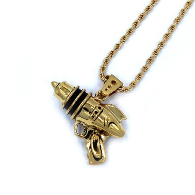 right angled shot of the Ray Gun Pendant in gold on a white surface