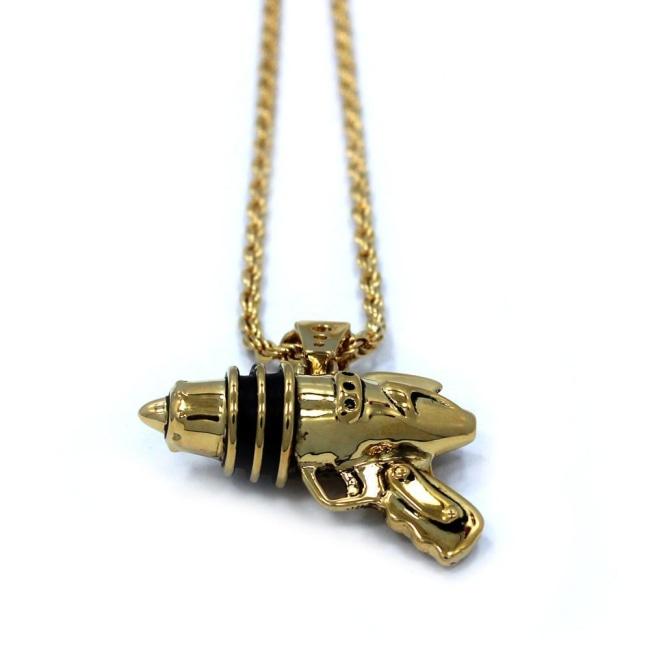 right up close shot of the Ray Gun Pendant in gold on a white surface