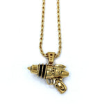 right side shot of the Ray Gun Pendant in gold on a white surface