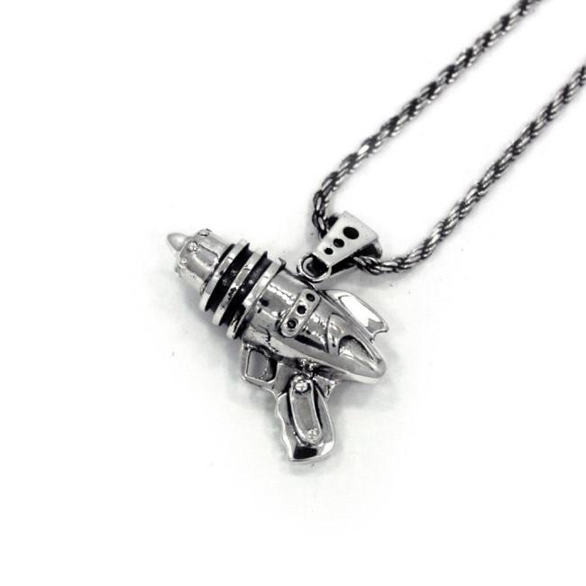 right angled shot of the Ray Gun Pendant in silver on a white surface